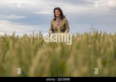 Lengdorf, Deutschland. 07.. Juli 2022. Michaela Kaliber (CSU), Staatsministerin für Ernährung, Landwirtschaft und Forsten, steht auf einem Winterweizenfeld während der jährlichen Ernte-Pressetour des Bayerischen Bauernverbandes und des Landwirtschaftsministeriums. Kaniber erfuhr von den Aussichten für die Ernte in Bayern. Kredit: Peter Kneffel/dpa/Alamy Live Nachrichten Stockfoto