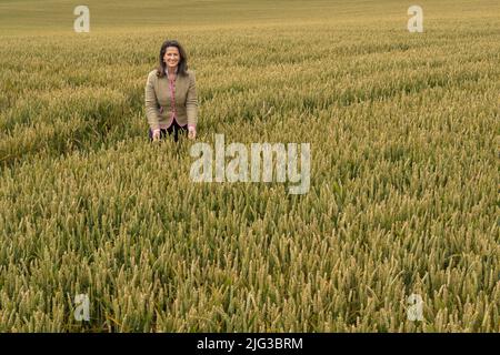 Lengdorf, Deutschland. 07.. Juli 2022. Michaela Kaliber (CSU), Staatsministerin für Ernährung, Landwirtschaft und Forsten, steht auf einem Winterweizenfeld während der jährlichen Ernte-Pressetour des Bayerischen Bauernverbandes und des Landwirtschaftsministeriums. Kaniber erfuhr von den Aussichten für die Ernte in Bayern. Kredit: Peter Kneffel/dpa/Alamy Live Nachrichten Stockfoto