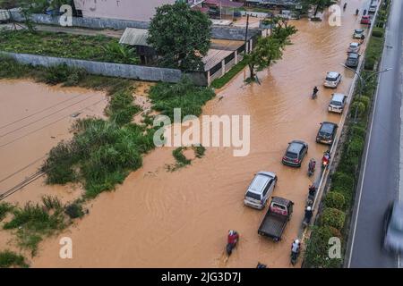 Kendari, Indonesien. 07.. Juli 2022. (ANMERKUNG DER REDAKTION: Bild aufgenommen mit Drohne) mehrere Fahrzeuge befinden sich auf einer überfluteten Straße in Kendari. Überschwemmungen überfluteten die umgehungsstraße von kendari und verursachten Staus auf der Straße. Zwei- und vierrädrige Fahrzeuge, die die Route überqueren wollten, mussten aufgrund der Überschwemmungen die Geschwindigkeit reduzieren. (Foto von Andry Denisah/SOPA Images/Sipa USA) Quelle: SIPA USA/Alamy Live News Stockfoto