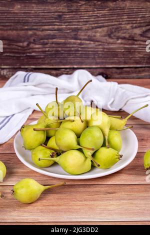 Frische Birne. Reife Birnen in Teller auf Holzhintergrund. Bulk Birne. Nahaufnahme Stockfoto