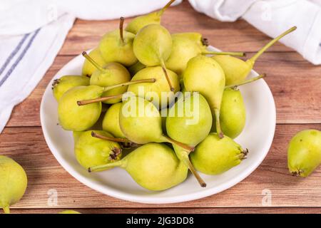 Frische Birne. Reife Birnen in Teller auf Holzhintergrund. Bulk Birne. Nahaufnahme Stockfoto