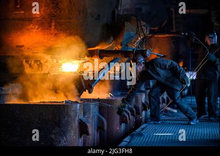 SAPORISCHSCHSCHJA, UKRAINE - 28. JUNI 2022 - Ein wimmelnd anmutendes Ganges eines offenen Herdofens ist in einem Stahlwerk in Saporischschschja, im Südosten der Ukraine, abgebildet. T Stockfoto