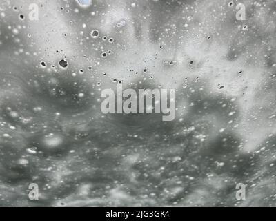 Abstrakter Hintergrund - Blick durch die Windschutzscheibe eines Autos, das durch die Waschanlage fährt Stockfoto