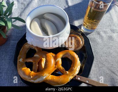 Traditionelles deutsches Mittagessen mit Brezelbrot und weißer Würstensuppe Stockfoto