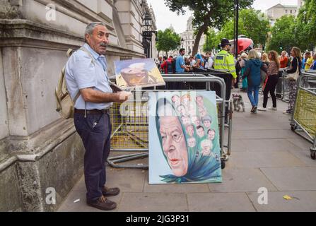 London, Großbritannien. 7.. Juli 2022. Der politische Künstler Kaya Mar steht neben seinem Kunstwerk, das die Königin und ehemalige Ministerpräsidenten darstellt, und malt außerhalb der Downing Street, während Johnson seinen Rücktritt ankündigt, das vermutlich sein letztes Gemälde von Boris Johnson sein wird. Stockfoto