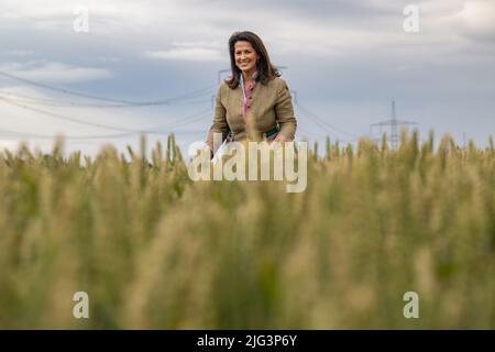 Lengdorf, Deutschland. 07.. Juli 2022. Michaela Kaniber (CSU), Staatsministerin für Ernährung, Landwirtschaft und Forsten, steht auf einem Winterweizenfeld während der jährlichen Ernte-Pressetour des Bayerischen Bauernverbandes und des Landwirtschaftsministeriums. Kaniber erfuhr von den Aussichten für die Ernte in Bayern. Kredit: Peter Kneffel/dpa/Alamy Live Nachrichten Stockfoto