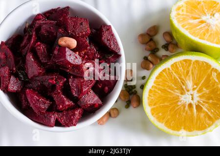 Selektiver Fokus auf sautierten oder Braten Rote Beete Gemüse, garniert mit Erdnüssen, Minze, süße Limette. Gesundes Essen Konzept der südindischen Beilage. Stockfoto