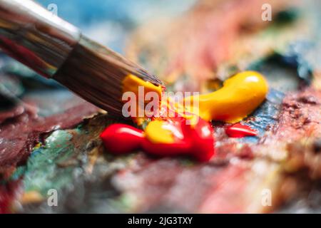Painter mischt Farbe auf der Palette. Nahaufnahme Stockfoto