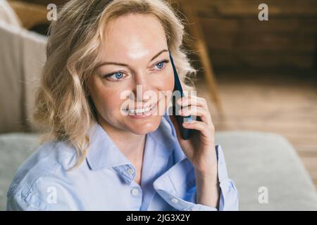Nahaufnahme einer blauäugigen Frau. Moderne drahtlose Kommunikation Stockfoto