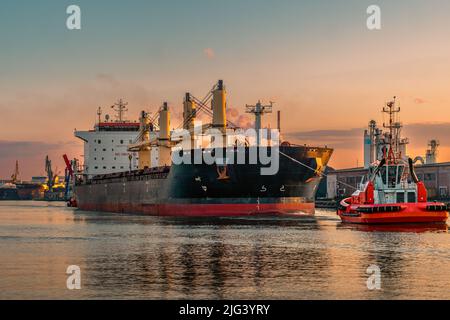 Frachtschiff mit Hilfe von Schleppern geht auf See Stockfoto