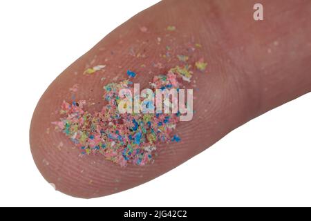 Eine Nahaufnahme des sehr feinen Mikroplastiks am Finger. Umweltverschmutzung, Abfallentsorgung Stockfoto