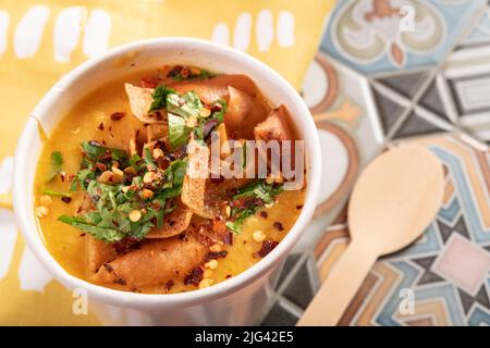 Mediterrane traditionelle marokkanische Linsensuppe, garniert mit Fladenbrot, Chili und Koriander zum Mitnehmen Stockfoto