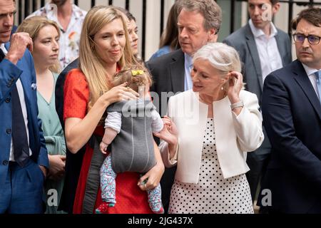 An dem Tag, an dem Premierminister Boris Johnson aus der Führung der Konservativen Partei zurücktritt und weiterhin als Premierminister dient, bis seine Partei einen Nachfolger wählt, steht Nadine Dorries neben Carrie Johnson, die ihr Baby Romy Iris Charlotte in der Hand hält, bevor ihr Mann in der Downing Street das Land anspricht. Am 7.. Juli 2022 in London, England. Stockfoto