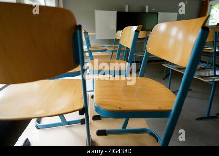 Hamburg, Deutschland. 07.. Juli 2022. In einem Klassenzimmer einer Schule stehen Stühle auf dem Schreibtisch. Kredit: Marcus Brandt/dpa/Alamy Live Nachrichten Stockfoto