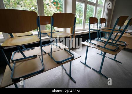 Hamburg, Deutschland. 07.. Juli 2022. In einem Klassenzimmer einer Schule stehen Stühle auf dem Schreibtisch. Kredit: Marcus Brandt/dpa/Alamy Live Nachrichten Stockfoto