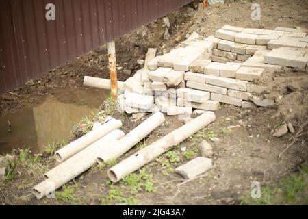 Erfolglose Konstruktion. Steinblöcke liegen schief. Details zum Bau der Kanalisation. Stockfoto