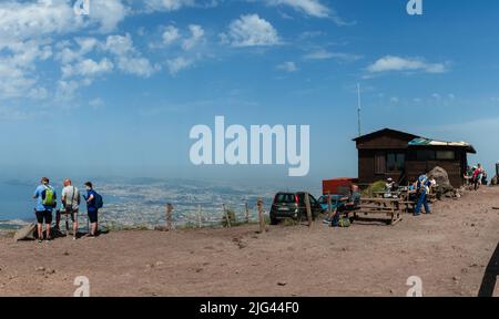 Neapel, Italien. 28.Mai 2022. Panorama vom Vesuv mit Souvenirladen und Touristen auf der Spitze und der Stadt Neapel im Hintergrund. Stockfoto