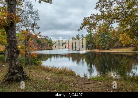 Die Stille des Byrd Lake im Cumberland Mountain State Park in Tennessee mit Reflexen der bunten Herbstbäume an einem bewölkten Tag Stockfoto