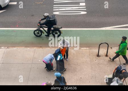 Kunden mit ihren Einkaufswagen und Einkaufstaschen, die mit Großzügigkeit aus der Speisekammer der Heiligen Apostel gefüllt sind, tauschen am Mittwoch, den 22. Juni 2022, in Chelsea in New York Waren aus. (© Richard B. Levine) Stockfoto