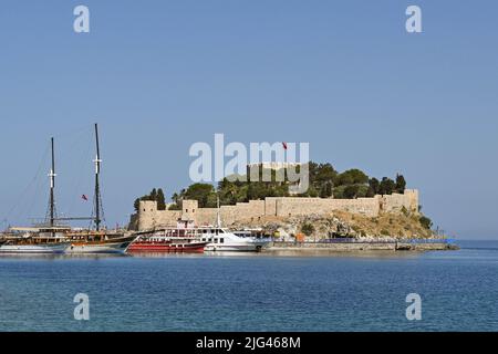 Kusadasi, Türkei - Juni Mai 2022: Touristenboote im Hafen mit Pigeon Island im Hintergrund vertäut Stockfoto