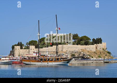 Kusadasi, Türkei - Juni Mai 2022: Touristenboote im Hafen mit Pigeon Island im Hintergrund vertäut Stockfoto