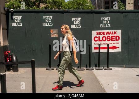 Frau passiert am Freitag, den 24. Juni 2022, einen Gehweg auf einer Baustelle in New York. (© Richard B. Levine) Stockfoto