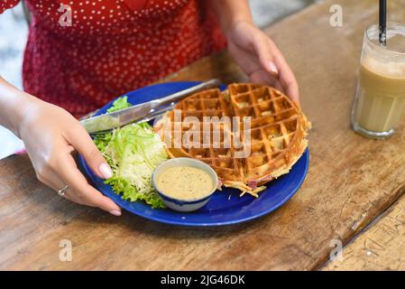 Frauenhände halten Teller mit hausgemachten Waffeln Stockfoto