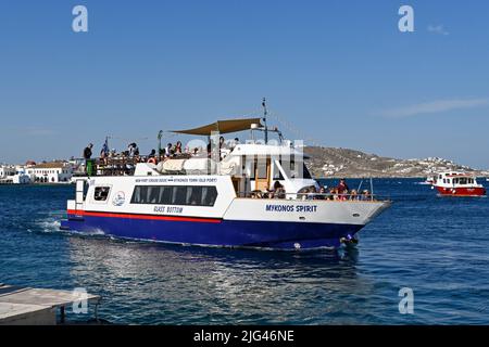 Mykonos, Griechenland - Juni 2022: Passagierfähre voller Menschen, die im Hafen auf der griechischen Insel Mykonos ankommen Stockfoto