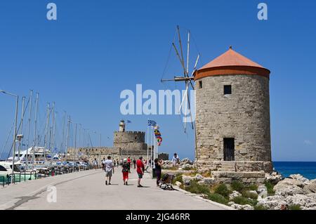 Rhodos, Griechenland - 2022. Mai: Traditionelle Steinwindmühlen an der Küste der Stadt Stockfoto