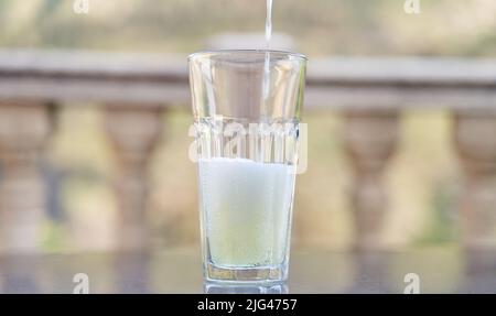 Limonade in Glas gießen. Erfrischendes Getränk im Sommer Stockfoto