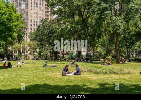 Am Dienstag, den 29. Juni 2022, sonnen sich die Menschen auf dem Oval Lawn im Madison Square Park in New York rund um die Installation von Cristina Iglesias „Landscape and Memory“. Die öffentliche Kunstinstallation stellt Cedar Creek nach, ein Gewässer, das einst unter dem Park floss. Die Installation läuft bis Dezember 4. (© Richard B. Levine) Stockfoto