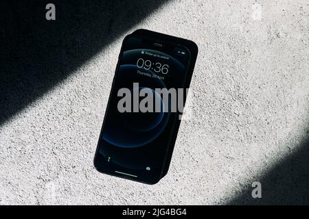 Königsberg, Russland - 15. April 2021: Schwarzes Apple iPhone 12 auf grauem Hintergrund. Neuestes Mobiltelefon. Stockfoto