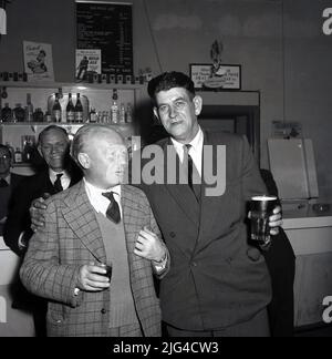 1950s, historische, zwei gut gekleidete Stahlarbeiter in Hemd und Krawatte, die nach einem Arbeitstag in der Bar des Unternehmens einen Drink in der Steel Company of Wales, Abbey Works, Port Talbot, Staff Bar, zu sich nehmen Stockfoto