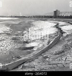 1950s, historische Ansicht der Baglan Bay und rechts große Erdarbeiten im Stahlwerk von Port Talbot, Wales, Großbritannien. Baglan Bay ist Teil der Küste der Swansea Bay. Stockfoto