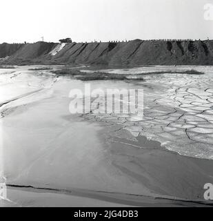 1950s, historische Ansicht der Baglan Bay und in der Ferne große Erdarbeiten bei den Stahlwerken in Port Talbot, Wales, Großbritannien. Baglan Bay ist Teil der Küste der Swansea Bay. Stockfoto