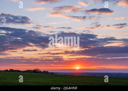 Landschaftsblick auf die Sonne und Wolken über landwirtschaftlich grünen Feldern Stockfoto
