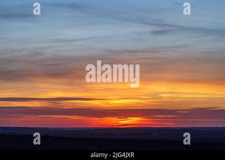 Landschaftsblick auf die Sonne und Wolken über landwirtschaftlich grünen Feldern Stockfoto