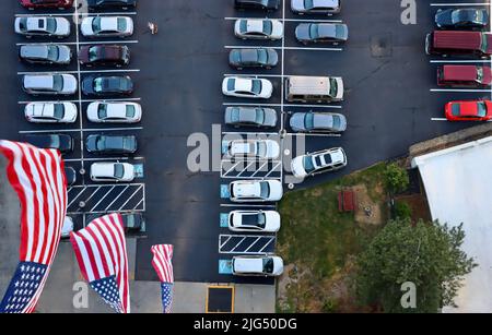 Amerikanische Flaggen von Balkonen über einem gefüllten Parkplatz Stockfoto