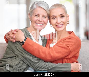 Sie ist mein Fels. Beschnittenes Porträt einer attraktiven jungen Frau und ihrer älteren Mutter, die zu Hause auf dem Sofa sitzt. Stockfoto