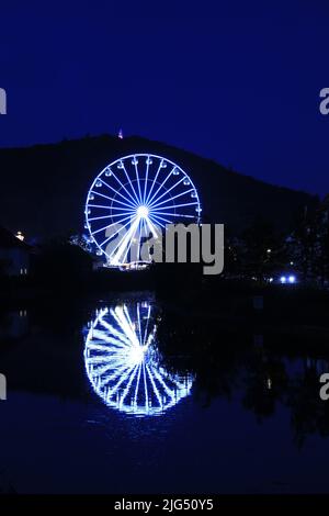 Beleuchtetes Riesenrad und Reflexion auf der Werra in Eschwege Stockfoto