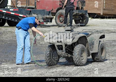 Menschen mit 4 Wheelers und Lastwagen auf Sonntagsausflug in den Schlamm für Spaß und Show von Kraft und Geschwindigkeit Nord FL Stockfoto