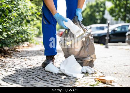 Mann Sammelt Müll Im Freien In Gummihandschuhen Stockfoto