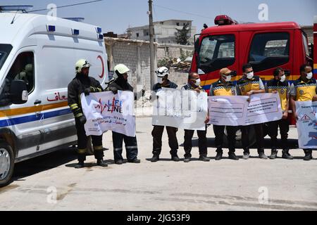 Sarmada, Idlib, Syrien, 7. Juli 2022 ، in der Nähe der Stadt Sarmada im von Rebellen gehaltenen Teil der nordwestlichen Provinz Idlib in Syrien versammeln sich am 7. Juli 2022 humanitäre Helfer, um gegen jede erwartete Schließung des Grenzübergangs Bab al-Hawa mit der Türkei zu demonstrieren und humanitäre Hilfe zu leisten Stockfoto