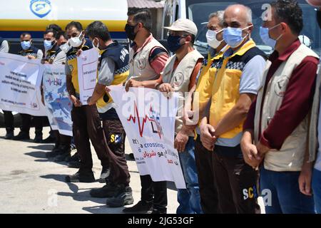 Sarmada, Idlib, Syrien, 7. Juli 2022 ، in der Nähe der Stadt Sarmada im von Rebellen gehaltenen Teil der nordwestlichen Provinz Idlib in Syrien versammeln sich am 7. Juli 2022 humanitäre Helfer, um gegen jede erwartete Schließung des Grenzübergangs Bab al-Hawa mit der Türkei zu demonstrieren und humanitäre Hilfe zu leisten Stockfoto