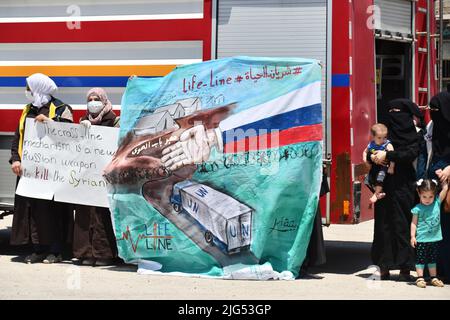 Sarmada, Idlib, Syrien, 7. Juli 2022 ، in der Nähe der Stadt Sarmada im von Rebellen gehaltenen Teil der nordwestlichen Provinz Idlib in Syrien versammeln sich am 7. Juli 2022 humanitäre Helfer, um gegen jede erwartete Schließung des Grenzübergangs Bab al-Hawa mit der Türkei zu demonstrieren und humanitäre Hilfe zu leisten Stockfoto