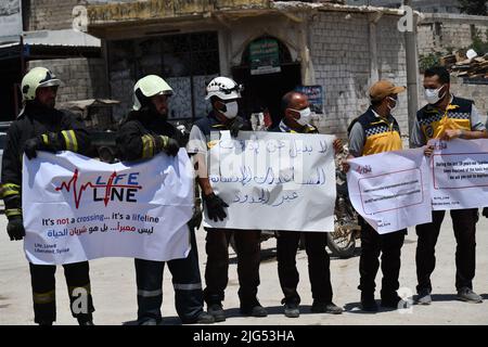 Sarmada, Idlib, Syrien, 7. Juli 2022 ، in der Nähe der Stadt Sarmada im von Rebellen gehaltenen Teil der nordwestlichen Provinz Idlib in Syrien versammeln sich am 7. Juli 2022 humanitäre Helfer, um gegen jede erwartete Schließung des Grenzübergangs Bab al-Hawa mit der Türkei zu demonstrieren und humanitäre Hilfe zu leisten Stockfoto