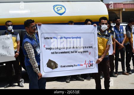 Sarmada, Idlib, Syrien, 7. Juli 2022 ، in der Nähe der Stadt Sarmada im von Rebellen gehaltenen Teil der nordwestlichen Provinz Idlib in Syrien versammeln sich am 7. Juli 2022 humanitäre Helfer, um gegen jede erwartete Schließung des Grenzübergangs Bab al-Hawa mit der Türkei zu demonstrieren und humanitäre Hilfe zu leisten Stockfoto