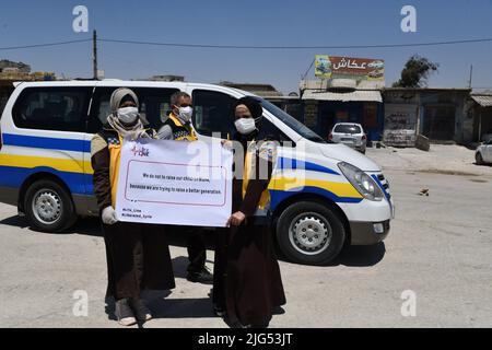 Sarmada, Idlib, Syrien, 7. Juli 2022 ، in der Nähe der Stadt Sarmada im von Rebellen gehaltenen Teil der nordwestlichen Provinz Idlib in Syrien versammeln sich am 7. Juli 2022 humanitäre Helfer, um gegen jede erwartete Schließung des Grenzübergangs Bab al-Hawa mit der Türkei zu demonstrieren und humanitäre Hilfe zu leisten Stockfoto