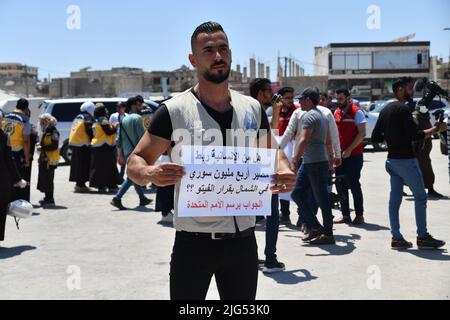 Sarmada, Idlib, Syrien, 7. Juli 2022 ، in der Nähe der Stadt Sarmada im von Rebellen gehaltenen Teil der nordwestlichen Provinz Idlib in Syrien versammeln sich am 7. Juli 2022 humanitäre Helfer, um gegen jede erwartete Schließung des Grenzübergangs Bab al-Hawa mit der Türkei zu demonstrieren und humanitäre Hilfe zu leisten Stockfoto