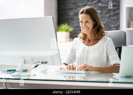Happy Geschäftsfrau, Arbeiten am Computer im Büro Stockfoto